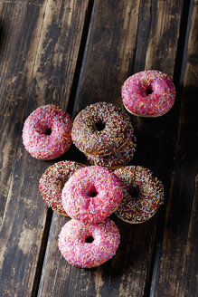 Bunte Donuts auf Holz mit Zuckerstreuseln - CSF28107