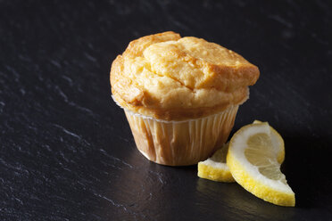 Frischer Zitronenmuffin auf schwarzem Schiefer mit Zitronenscheiben - CSF28112