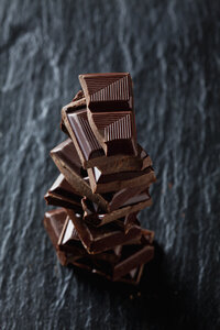 Stapel von Schokoladenstücken auf schwarzem Schiefer - CSF28121