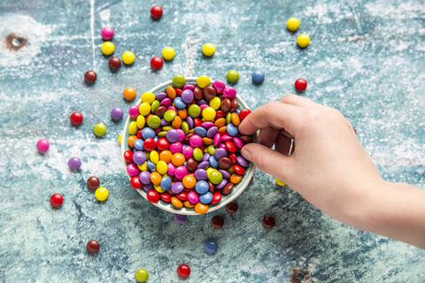 Girl's hand taking chocolate button stock photo