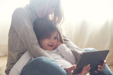 Mother and little daughter using tablet at home - RTBF00759