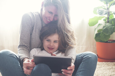 Mother and little daughter using tablet at home - RTBF00761