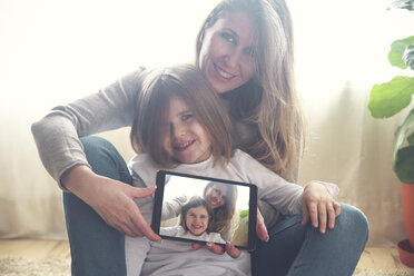 Porträt von Mutter und kleiner Tochter zu Hause mit Tablet und Selfie - RTBF00764