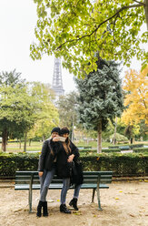 Frankreich, Paris, zwei junge Frauen machen ein Selfie im Park mit dem Eiffelturm im Hintergrund - MGOF03093