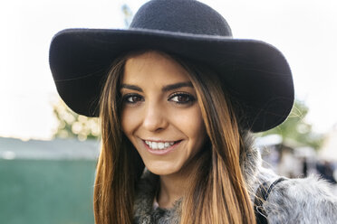 Portrait of smiling young woman wearing a hat - MGOF03119