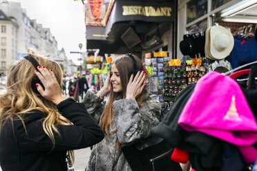 Frankreich, Paris, zwei Touristinnen an einem Souvenirstand - MGOF03120