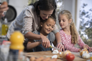 Mother helping daughters in kitchen - ZEF13203