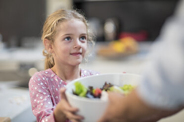 Girl receiving bowl of salad - ZEF13231