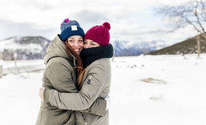 Zwei junge Frauen umarmen sich im Schnee - MGOF03127