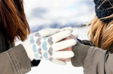 Zwei Freunde wärmen ihre Hände im Schnee - MGOF03128