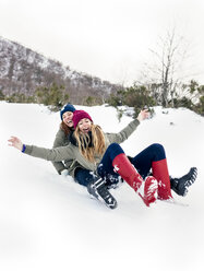 Zwei beste Freunde haben Spaß mit einem Schlitten im Schnee - MGOF03132