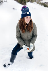 Lächelnde junge Frau im Schnee - MGOF03139