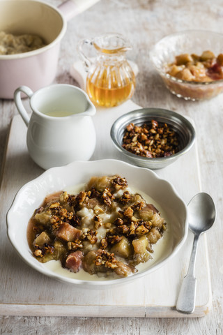 Schüssel Porridge mit Rhabarberkompott, Honig und Nüssen, lizenzfreies Stockfoto