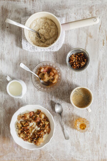 Frühstück mit einer Schüssel Porridge mit Rhabarberkompott, Honig und Nüssen und einer Tasse Kaffee - EVGF03159