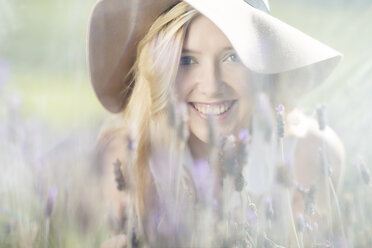 Porträt einer lächelnden jungen Frau in einem Lavendelfeld - ZEF13232