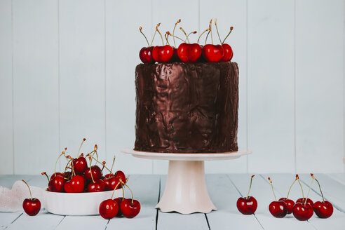 Cake with chocolate icing and cherries on cake stand - RTBF00786