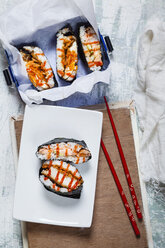 Sushi-Sandwiches mit Stäbchen in einer Schachtel - SBDF03159