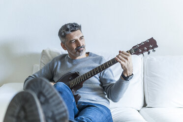 Älterer Mann spielt zu Hause E-Gitarre - TCF05332