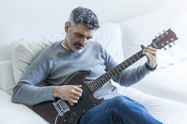 Älterer Mann spielt zu Hause E-Gitarre - TCF05333