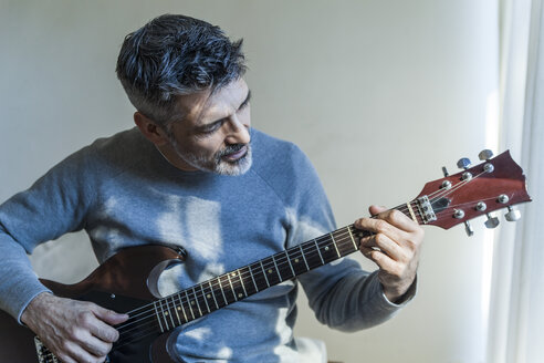 Älterer Mann spielt zu Hause E-Gitarre - TCF05350