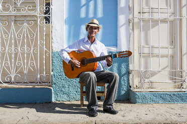 Cuba, Trinidad, portrait of man playing guitar on the street - MAUF01022