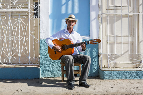 Kuba, Trinidad, Porträt eines Gitarre spielenden Mannes auf der Straße - MAUF01022