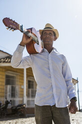 Cuba, portrait of man with guitar on his shoulder - MAUF01023