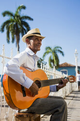 Cuba, Trinidad, man playing guitar on the street - MAUF01024