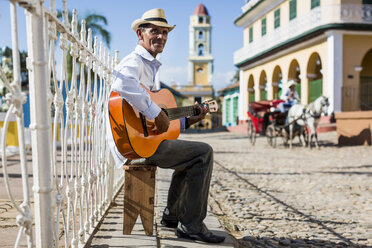 Cuba, Trinidad, man playing guitar on the street - MAUF01025