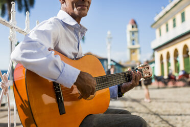 Kuba, Trinidad, Mann spielt Gitarre auf der Straße, Teilansicht - MAUF01026