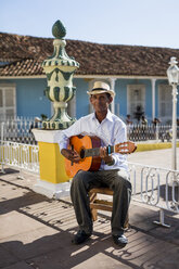 Cuba, Trinidad, man playing guitar on the street - MAUF01027