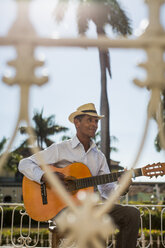 Cuba, Trinidad, man playing guitar on the street - MAUF01028