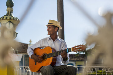 Cuba, Trinidad, man playing guitar on the street - MAUF01029