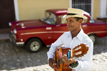 Cuba, Trinidad, man playing guitar on the street - MAUF01039