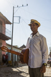 Kuba, Trinidad, Mann mit Gitarre auf der Straße - MAUF01041