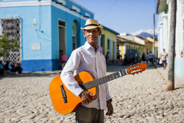 Kuba, Trinidad, Mann mit Gitarre auf der Straße stehend - MAUF01042
