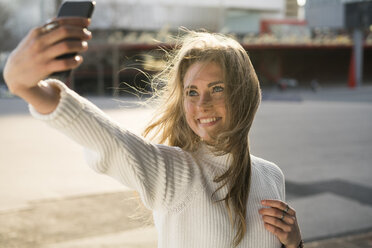 Portrait of young woman taking selfie with smartphone - KKAF00548