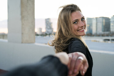 Spain, Barcelona, portrait of happy young woman holding hand - KKAF00568