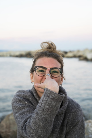 Porträt einer lächelnden jungen Frau mit Brille, lizenzfreies Stockfoto