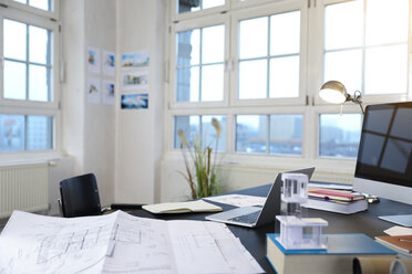 Schreibtisch mit Bauplan in einem modernen informellen Büro - FKF02194