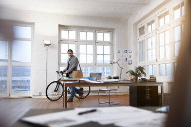 Mann mit Fahrrad in einem modernen informellen Büro - FKF02201