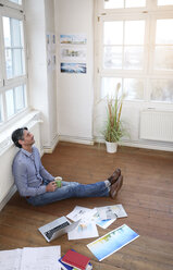 Mann sitzt auf dem Boden im Büro - FKF02214