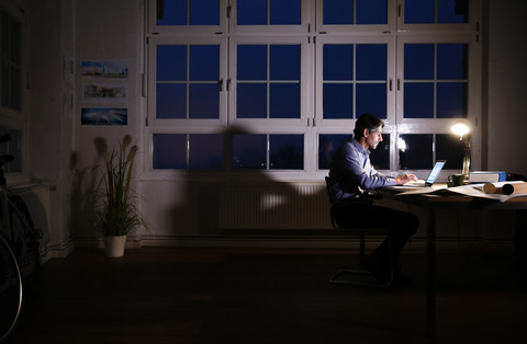 Mann arbeitet lange im Büro, lizenzfreies Stockfoto