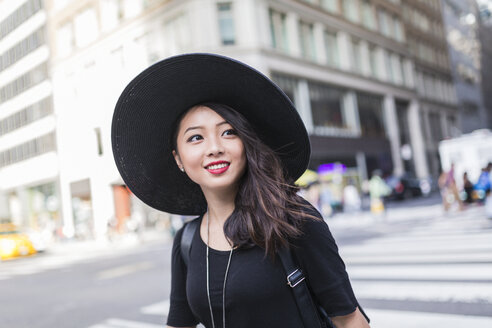 USA, New York City, Manhattan, Porträt einer modischen jungen Frau mit schwarzem Hut - GIOF02480