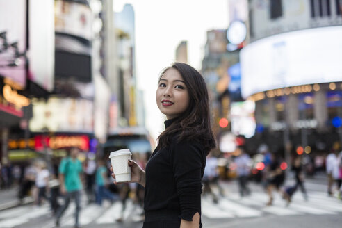 USA, New York City, Manhattan, junge Frau mit Kaffee zum Mitnehmen auf der Straße - GIOF02531