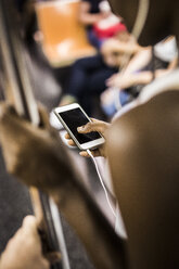 Woman using cell phone at underground train - GIOF02548