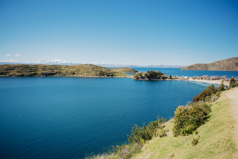 Bolivien, Titicacasee, Isla del sol, Gemeinde Challapampa am Seeufer mit schneebedeckten Anden im Hintergrund, lizenzfreies Stockfoto