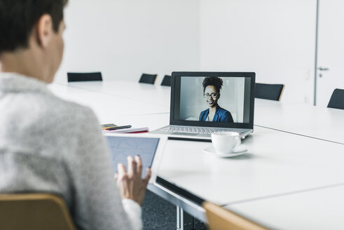 Geschäftsfrau mit einer Videokonferenz im Büro - UUF10274