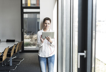 Businesswoman using tablet at the window - UUF10284