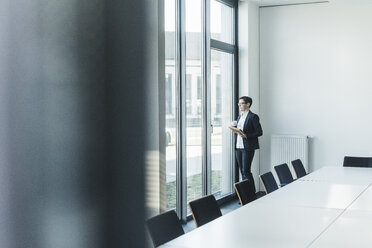 Businesswoman looking out of office window - UUF10306